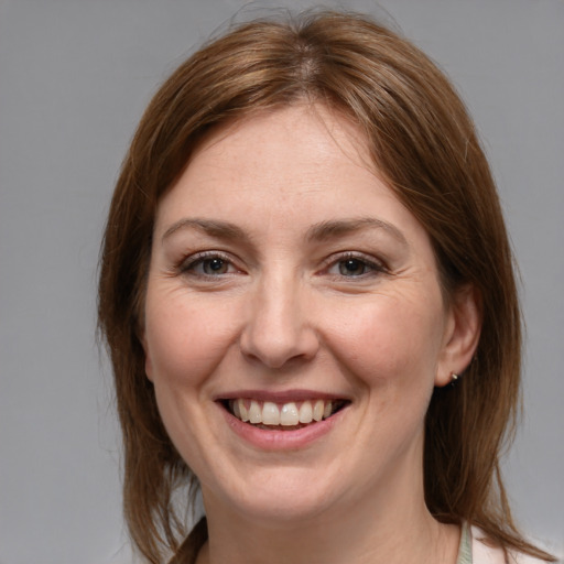 Joyful white adult female with medium  brown hair and grey eyes