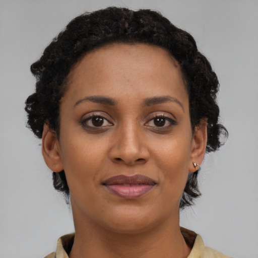 Joyful black young-adult female with short  brown hair and brown eyes