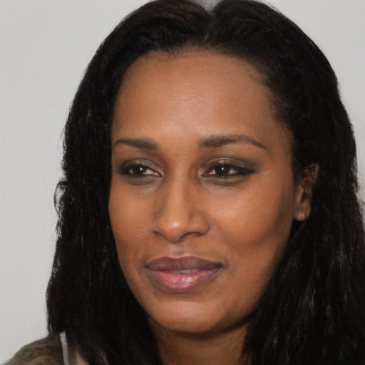 Joyful black young-adult female with long  black hair and brown eyes