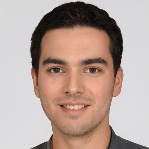 Joyful white young-adult male with short  black hair and brown eyes