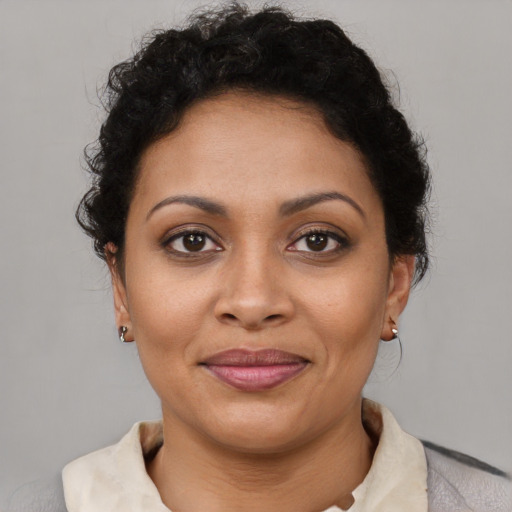Joyful latino adult female with short  brown hair and brown eyes