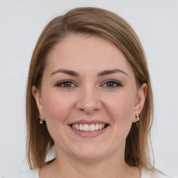 Joyful white young-adult female with medium  brown hair and grey eyes