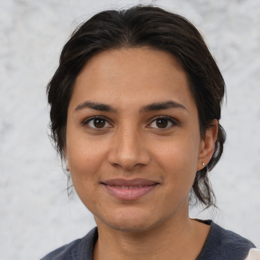 Joyful latino young-adult female with medium  brown hair and brown eyes