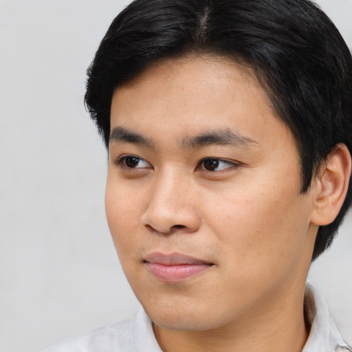 Joyful asian young-adult male with short  black hair and brown eyes