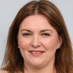 Joyful white adult female with long  brown hair and grey eyes