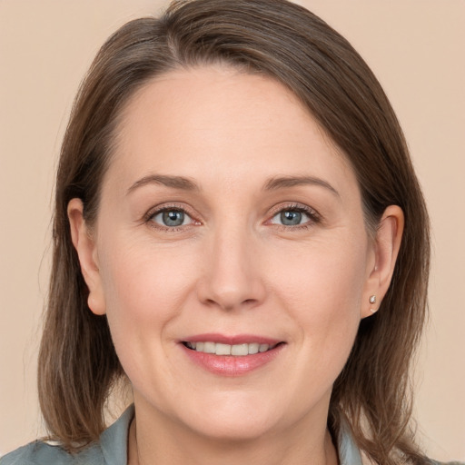 Joyful white adult female with long  brown hair and grey eyes