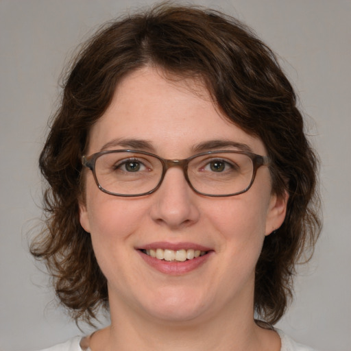 Joyful white adult female with medium  brown hair and blue eyes