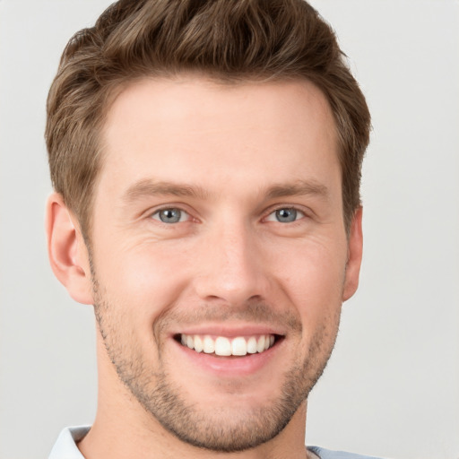 Joyful white young-adult male with short  brown hair and grey eyes