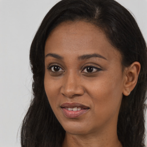 Joyful black young-adult female with long  brown hair and brown eyes