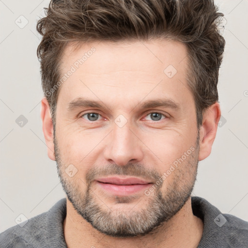 Joyful white adult male with short  brown hair and grey eyes