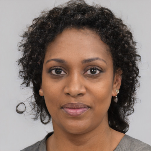 Joyful black young-adult female with medium  black hair and brown eyes