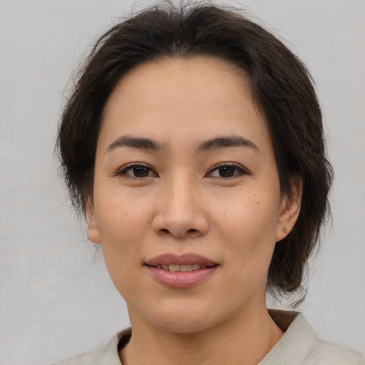 Joyful asian young-adult female with medium  brown hair and brown eyes