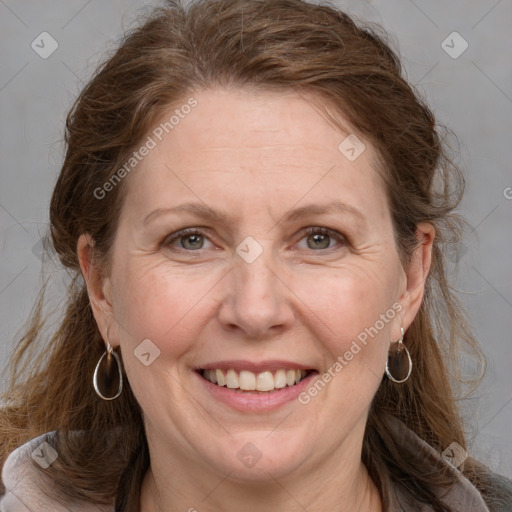 Joyful white adult female with long  brown hair and grey eyes