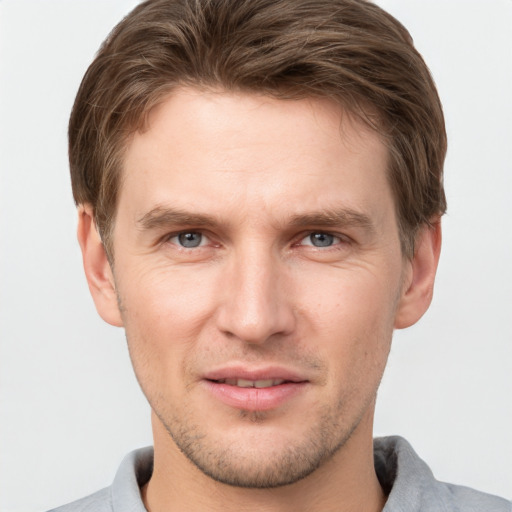 Joyful white young-adult male with short  brown hair and grey eyes