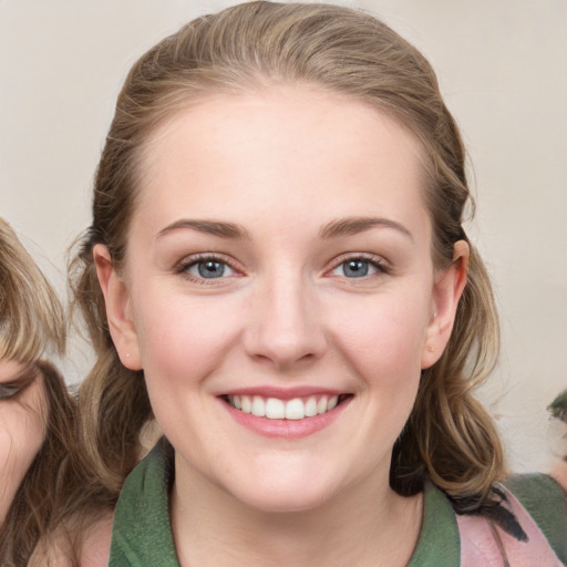 Joyful white young-adult female with medium  brown hair and blue eyes