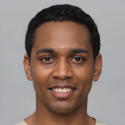 Joyful black young-adult male with short  black hair and brown eyes