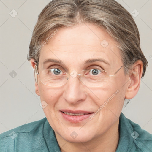 Joyful white adult female with medium  brown hair and blue eyes