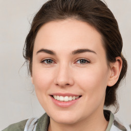 Joyful white young-adult female with medium  brown hair and green eyes