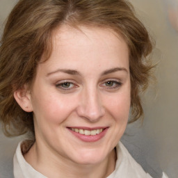 Joyful white young-adult female with medium  brown hair and green eyes