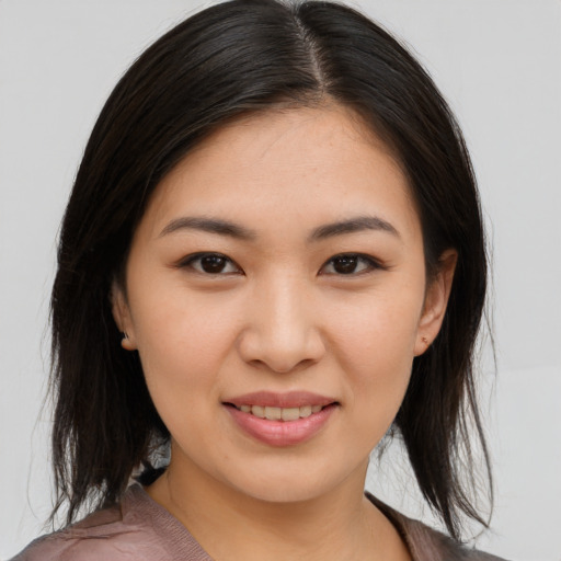 Joyful asian young-adult female with medium  brown hair and brown eyes