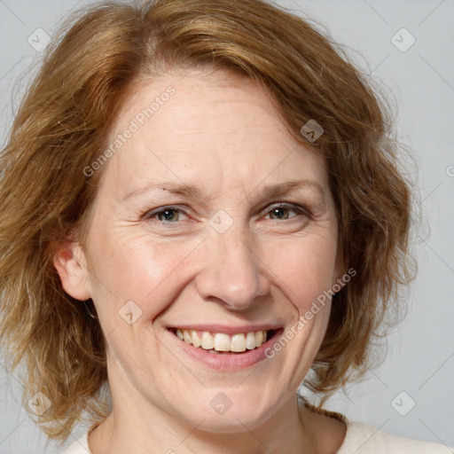 Joyful white adult female with medium  brown hair and blue eyes