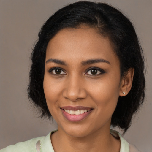 Joyful black young-adult female with long  brown hair and brown eyes