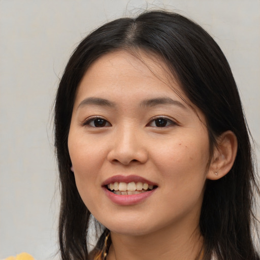 Joyful asian young-adult female with long  brown hair and brown eyes