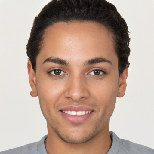 Joyful white young-adult male with short  black hair and brown eyes