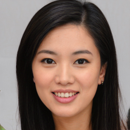 Joyful asian young-adult female with long  black hair and brown eyes