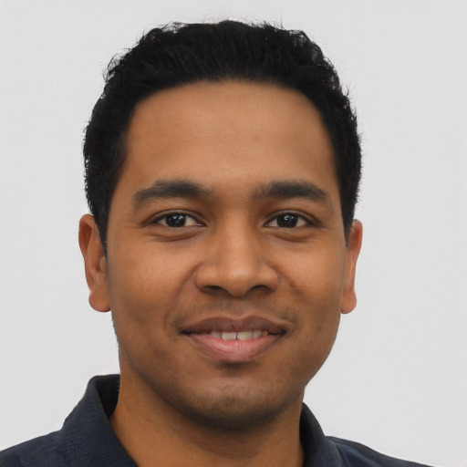 Joyful latino young-adult male with short  black hair and brown eyes