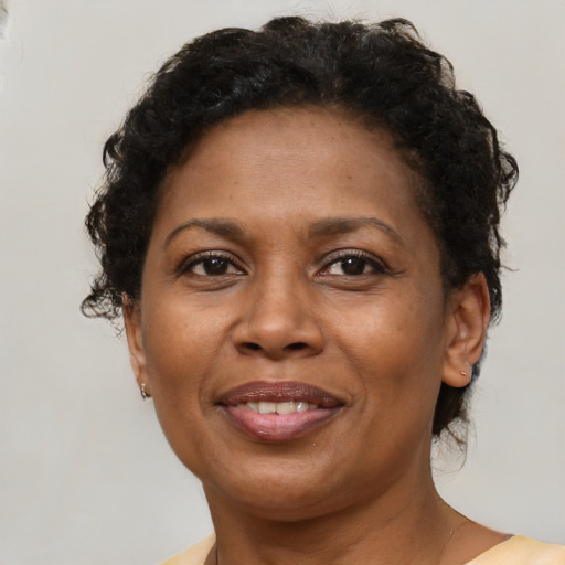 Joyful black adult female with short  brown hair and brown eyes