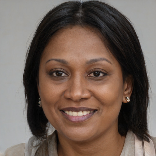 Joyful latino adult female with medium  brown hair and brown eyes