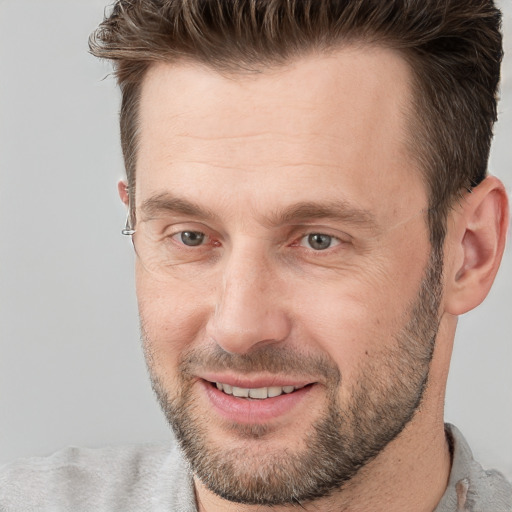 Joyful white adult male with short  brown hair and grey eyes