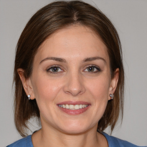 Joyful white young-adult female with medium  brown hair and blue eyes