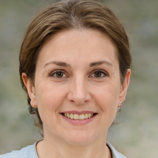 Joyful white adult female with medium  brown hair and green eyes