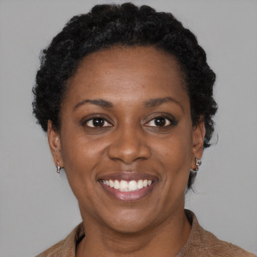 Joyful black adult female with short  brown hair and brown eyes