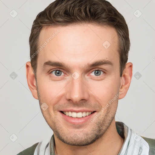 Joyful white young-adult male with short  brown hair and grey eyes