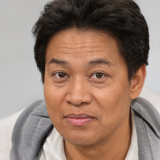 Joyful asian adult male with short  brown hair and brown eyes