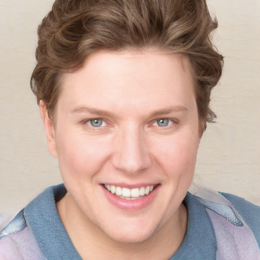 Joyful white young-adult female with short  brown hair and blue eyes