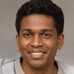 Joyful latino young-adult male with short  brown hair and brown eyes