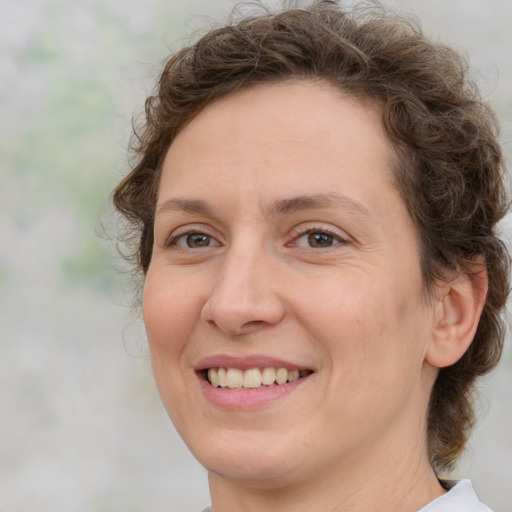 Joyful white adult female with medium  brown hair and green eyes