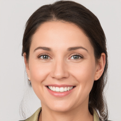 Joyful white young-adult female with medium  brown hair and grey eyes