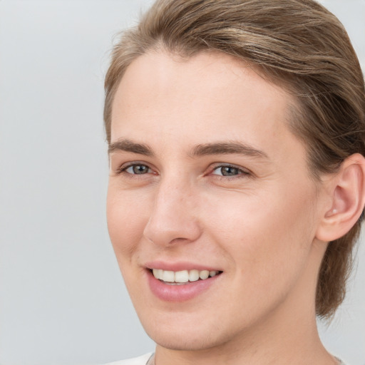 Joyful white young-adult female with medium  brown hair and grey eyes