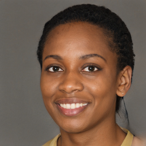Joyful black young-adult female with long  black hair and brown eyes