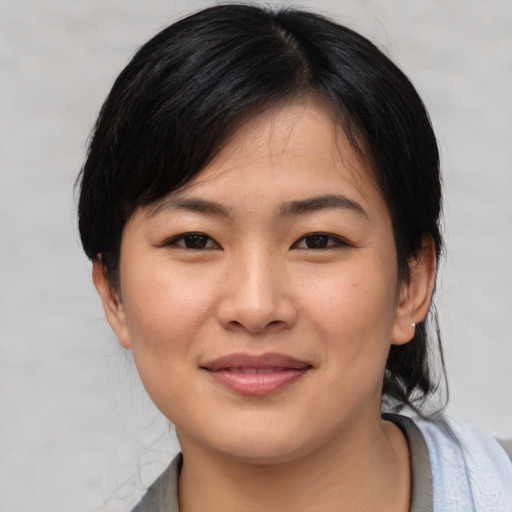 Joyful asian young-adult female with medium  brown hair and brown eyes