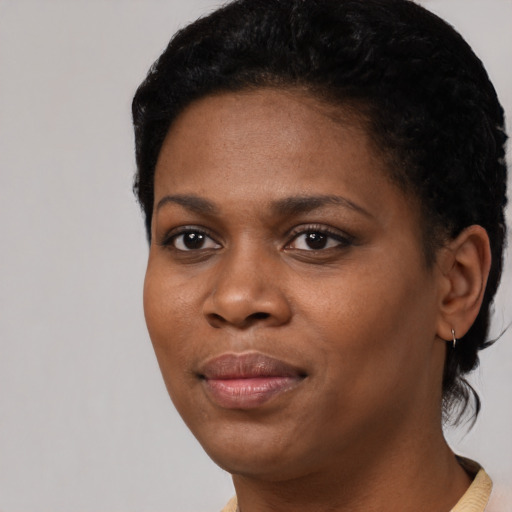 Joyful black young-adult female with short  black hair and brown eyes