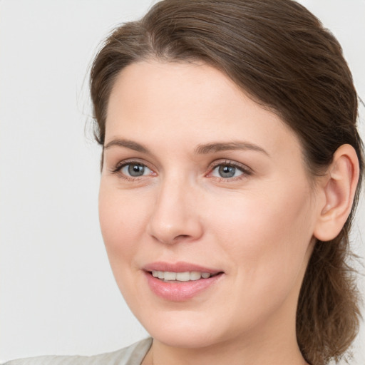 Joyful white young-adult female with medium  brown hair and blue eyes