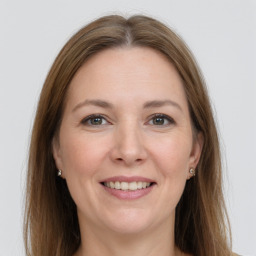 Joyful white adult female with long  brown hair and grey eyes