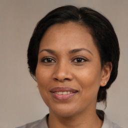 Joyful black adult female with medium  brown hair and brown eyes