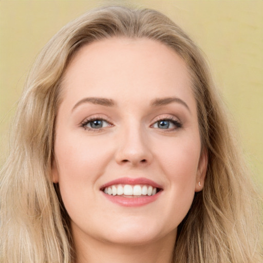 Joyful white young-adult female with long  brown hair and blue eyes